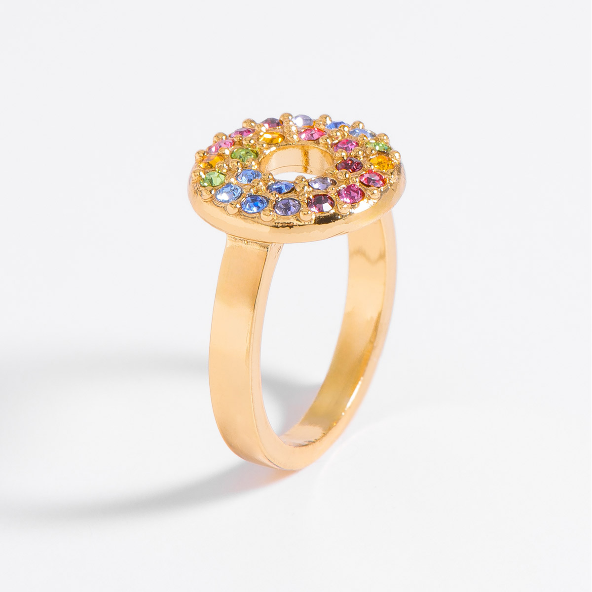 Colorido anillo con diseño de disco incrustado con piedras multicolores, en baño de oro 18k. Arma un look lleno de coloer complementándolo con tu pulsera y aretes.
-        Anillo
-        Medias del 6 al 9
-        Baño de Oro 18k
-        Piedras en tono morado,  rosa, verde, azul, amarillo y lila
