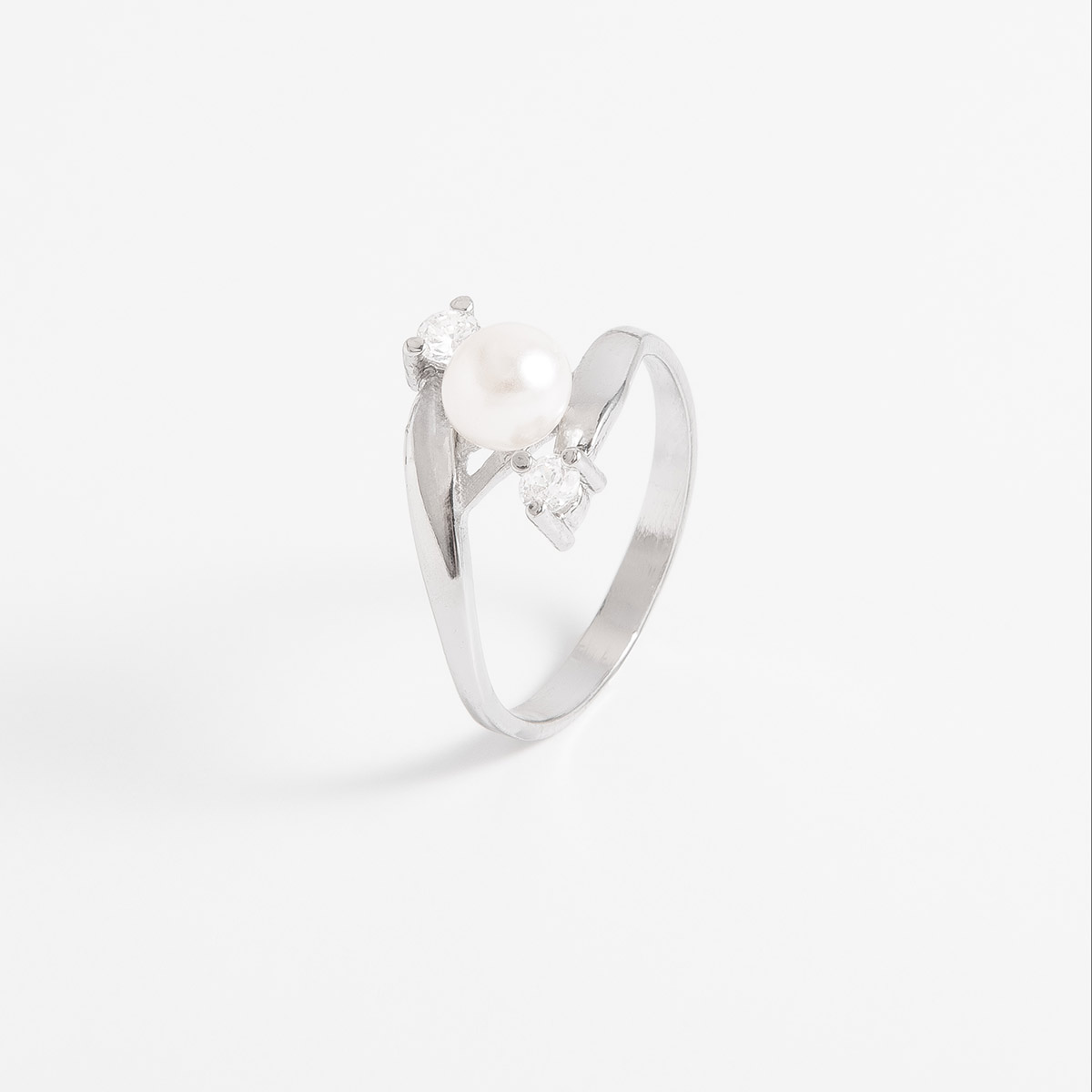 Anillo en baño de platino, con un diseño minimalista; una perla en tono crema rodeada de dos piedras  Diamonice. Combínalo con tu collar y aretes.
-        Anillo
-        Medidas del 5 al 9
-        Baño de Platino
-        Perla en tono crema
-         Diamonice en tono cristal