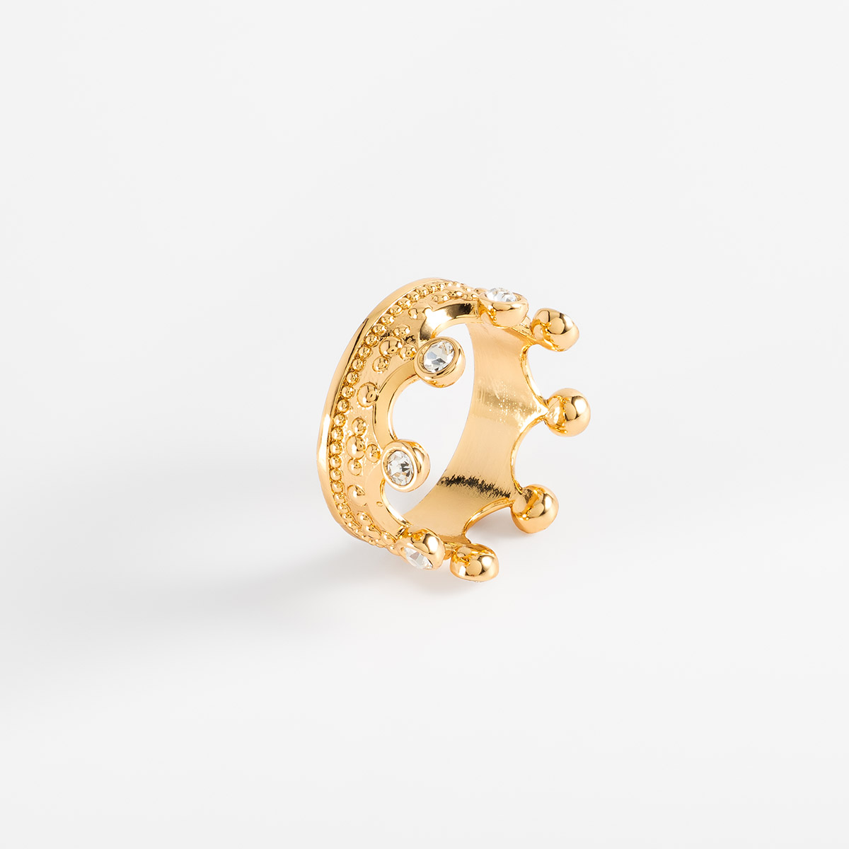 Anillo en baño de oro diseño corona con piedras en tono cristal