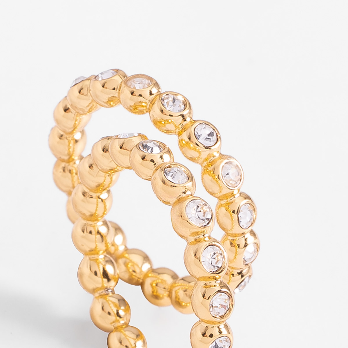 Anillo en baño de oro con piedras en tono cristal diseño esferas