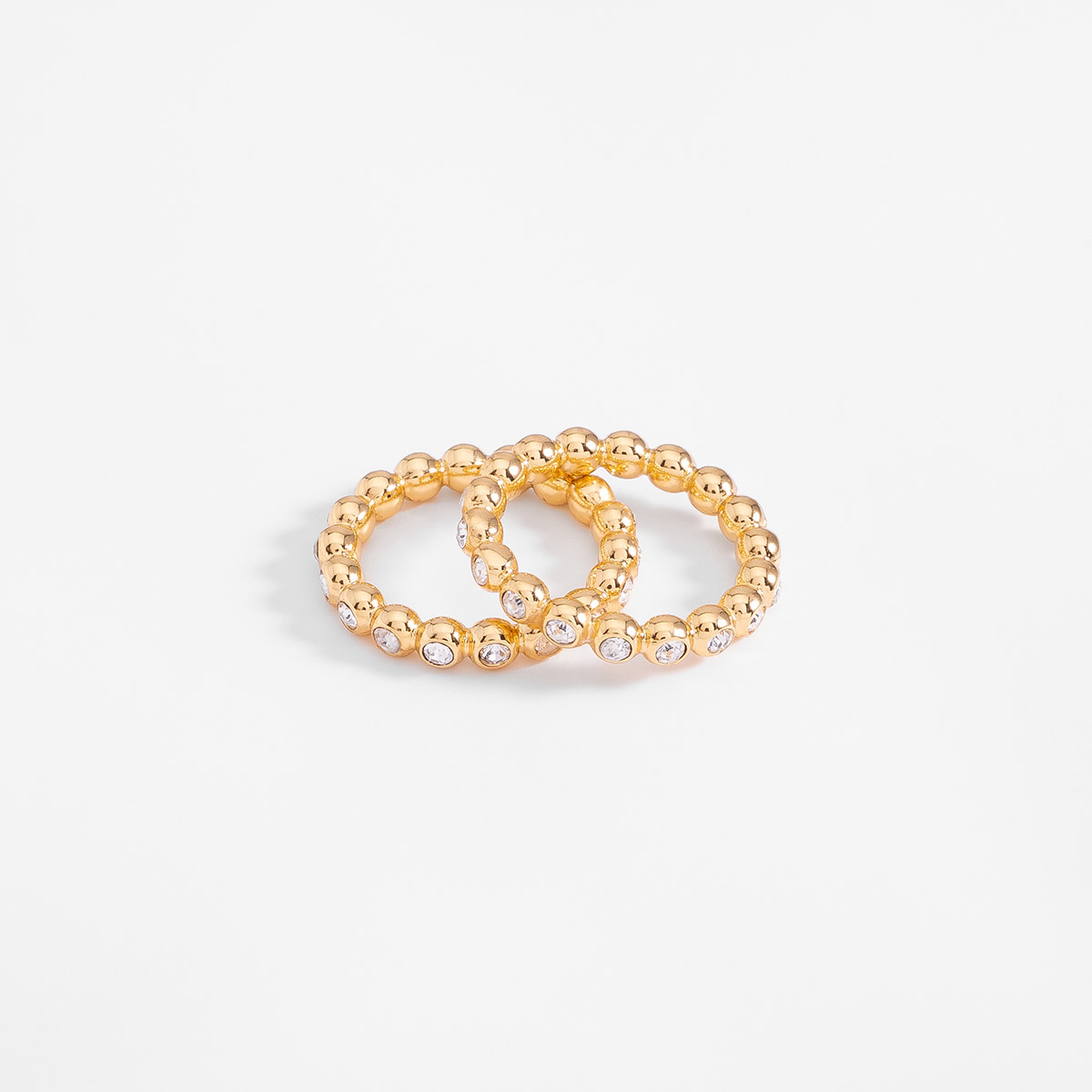 Anillo en baño de oro con piedras en tono cristal diseño esferas