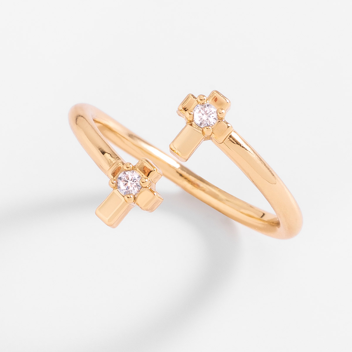 Anillo en baño de oro con cruces y piedras en tono cristal