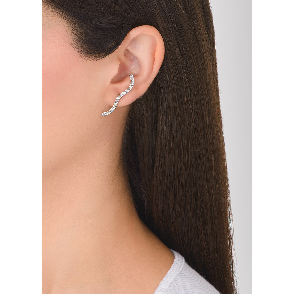 Encuentra un delicado diseño de línea en ondas con estos hermosos aretes en baño de platino, incrustados con una fila de finas piedras en tono cristal.
-        Aretes largos
-        Poste
-        Baño de Platino
-        Piedras en tono cristal
