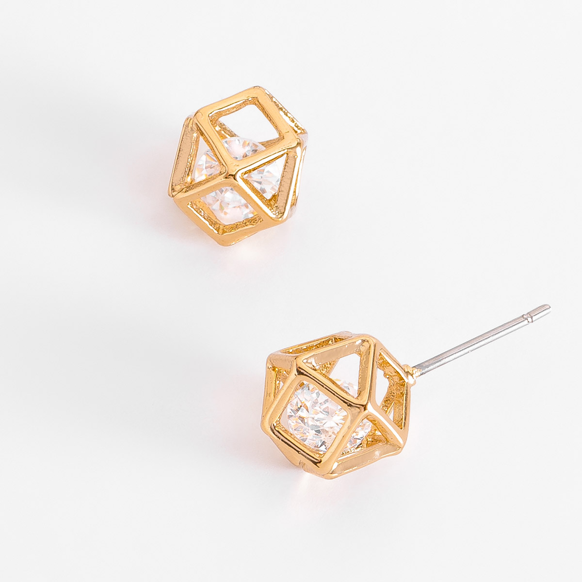 La innovación siempre te acompañará con estos aretes compuestos por una estructura geométrica tridimensional en forma de cubo abierto, que enmarcan una piedra en tono cristal al centro.
-        Aretes chicos
-         Poste
-        Baño de Oro 18k
-        Piedra en tono cristal
