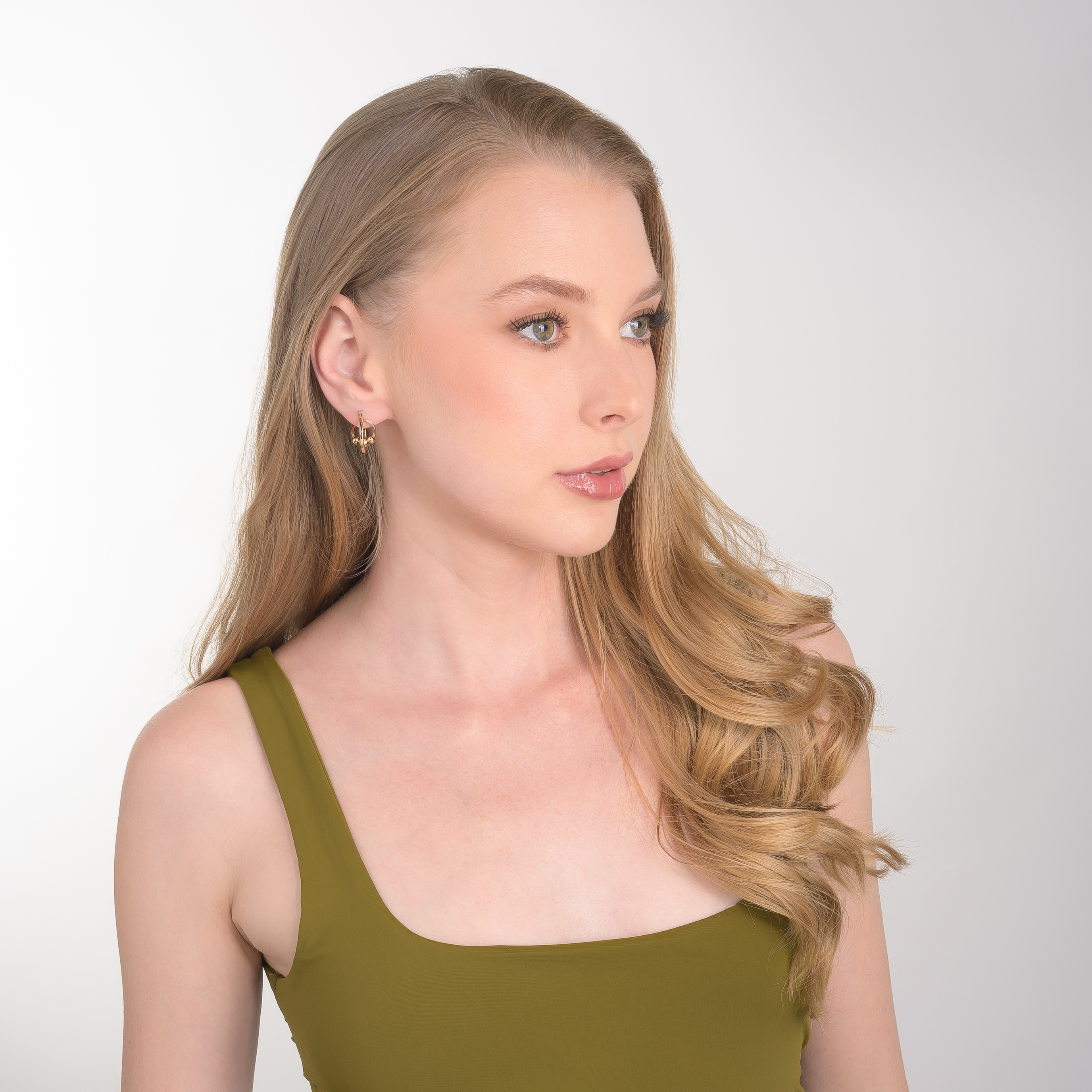 Aretes en baño de oro con forma de aro y detalles de esferas pulidas