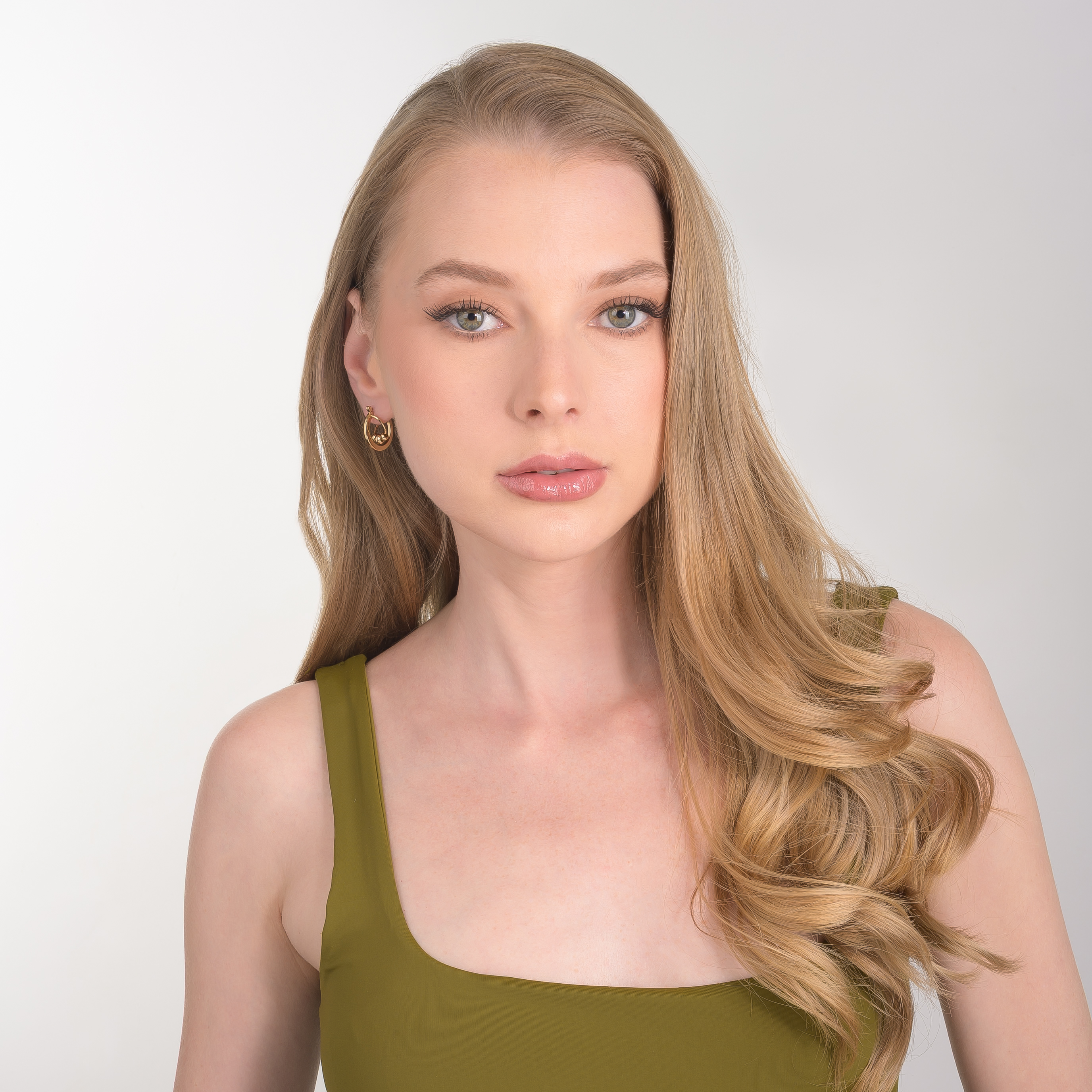 Aretes en baño de oro con forma de aro y detalles de esferas pulidas