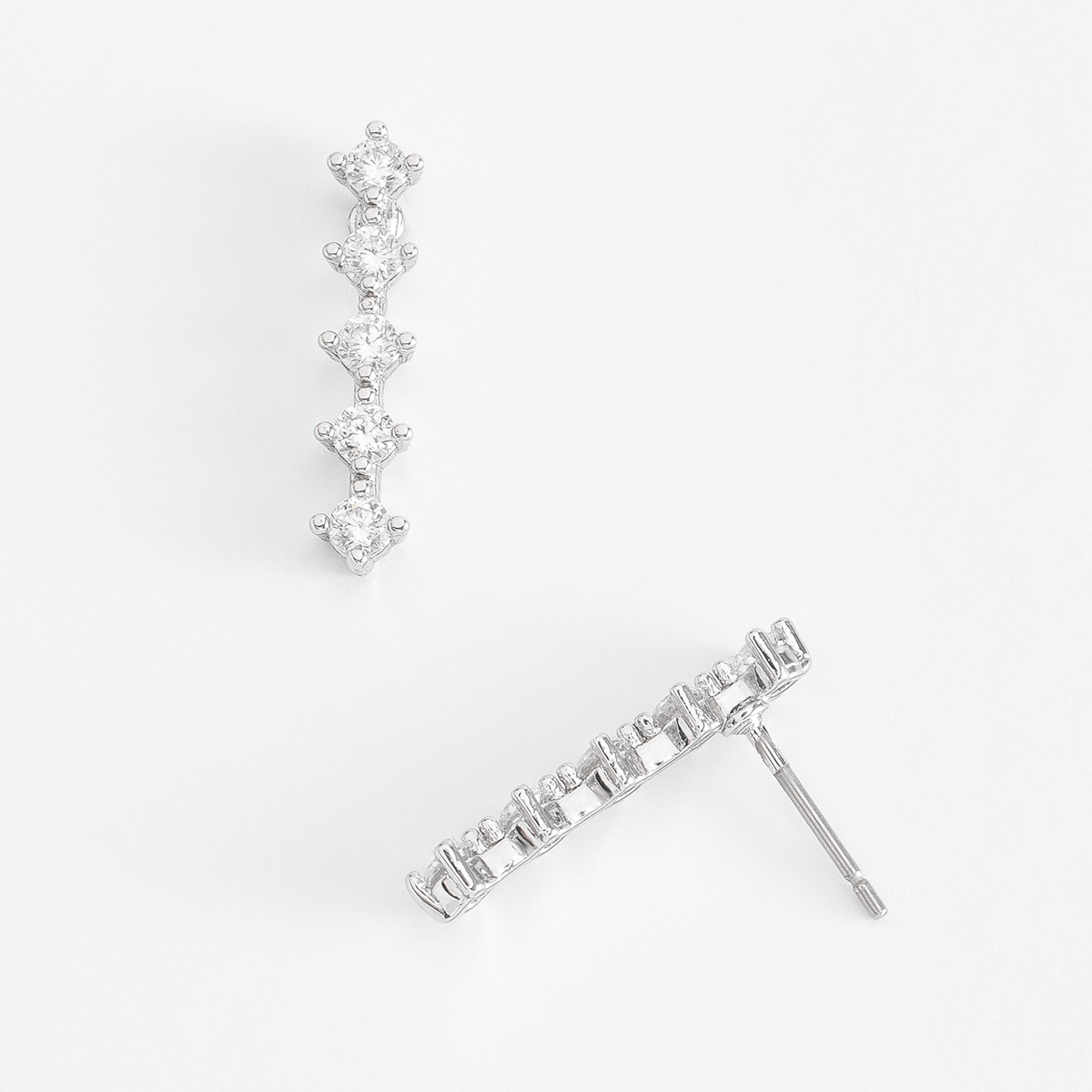 Aretes en baño de platino, compuestos por una fila de cinco piedras Diamonice en tono cristal, alineadas en una forma vertical.
-        Aretes
-        Poste
-        Baño de Platino        
-        Diamonice en tono cristal
