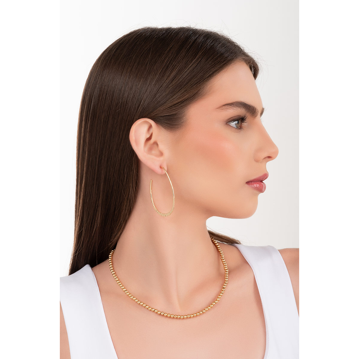 Aretes en baño de oro con diseño de aro martillado que suma un aire contemporáneo y versátil, ideales para destacar tu personalidad.