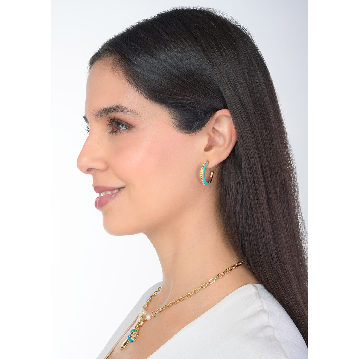 Aretes en baño de oro con esmalte en tono verde agua y un toque brillante, fusionando modernidad y frescura para realzar cualquier estilo.