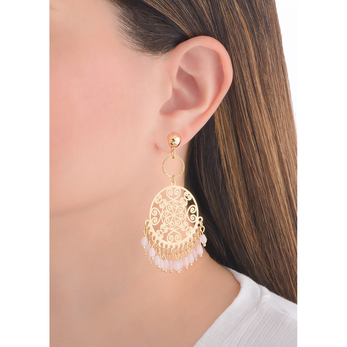 Extravagantes aretes en forma circular con patrones tipo filigranas, evocando detalles florales, arabescos y de corazones. En la parte inferior cuelgan delicadas piedras en tono rosa, añadiendo movimiento a la pieza.
-        Aretes con poste
-        Baño de Oro 18k
-        Piedras en tono rosa.
