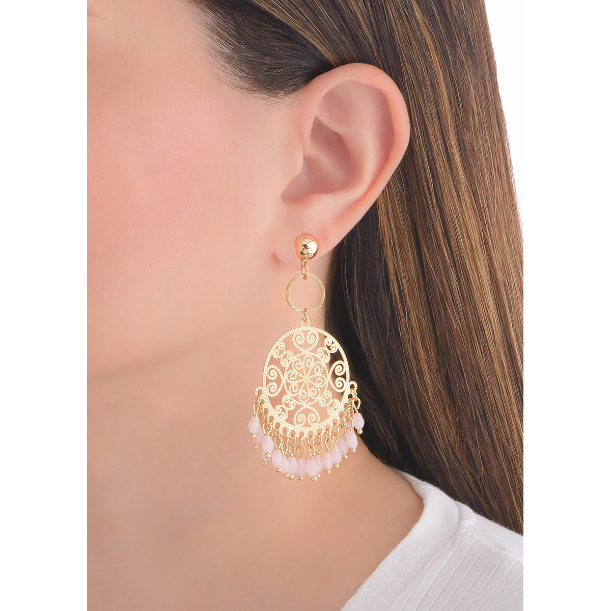 Extravagantes aretes en forma circular con patrones tipo filigranas, evocando detalles florales, arabescos y de corazones. En la parte inferior cuelgan delicadas piedras en tono rosa, añadiendo movimiento a la pieza.
-        Aretes con poste
-        Baño de Oro 18k
-        Piedras en tono rosa.
