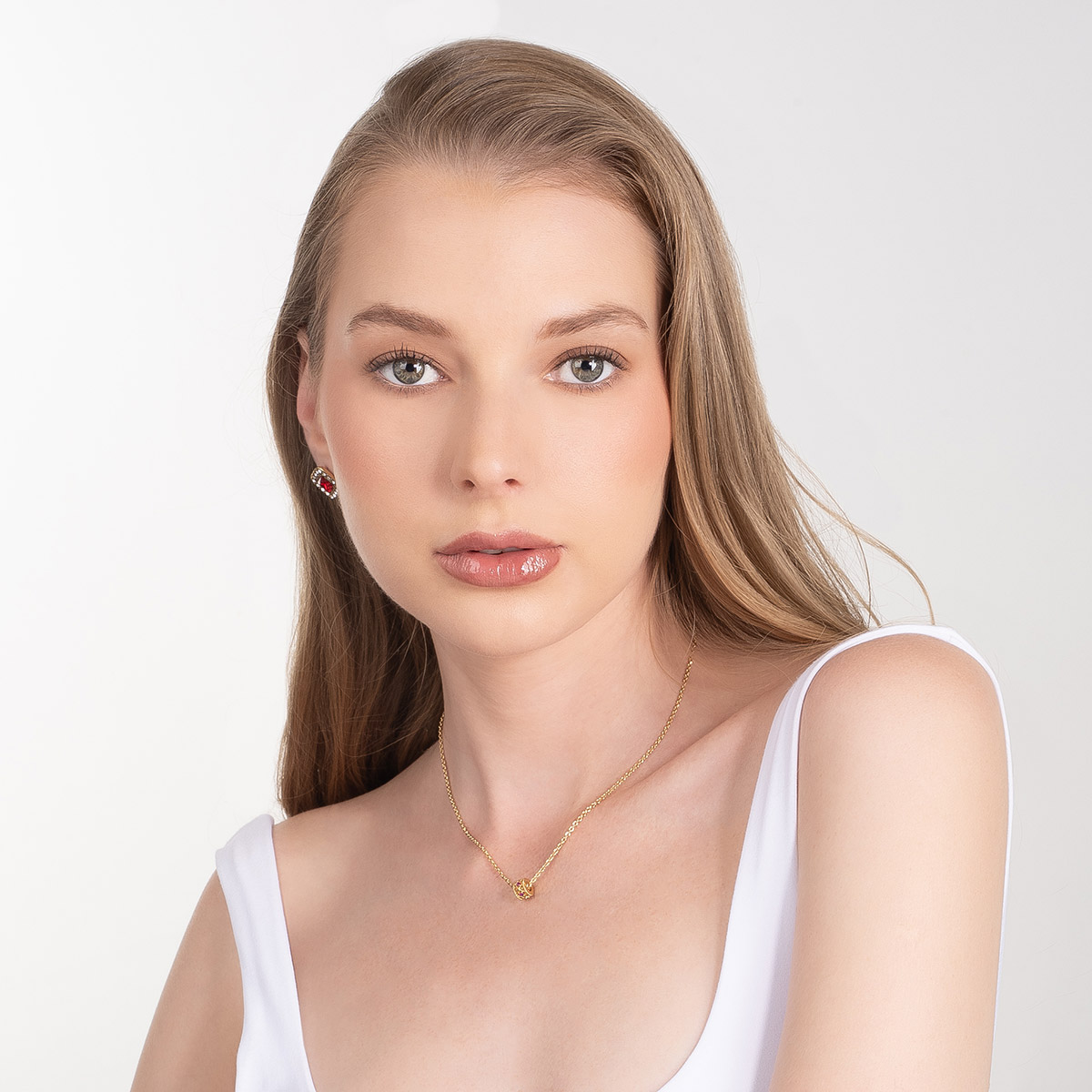 Aretes en baño de oro centro rojo borde piedras brillante