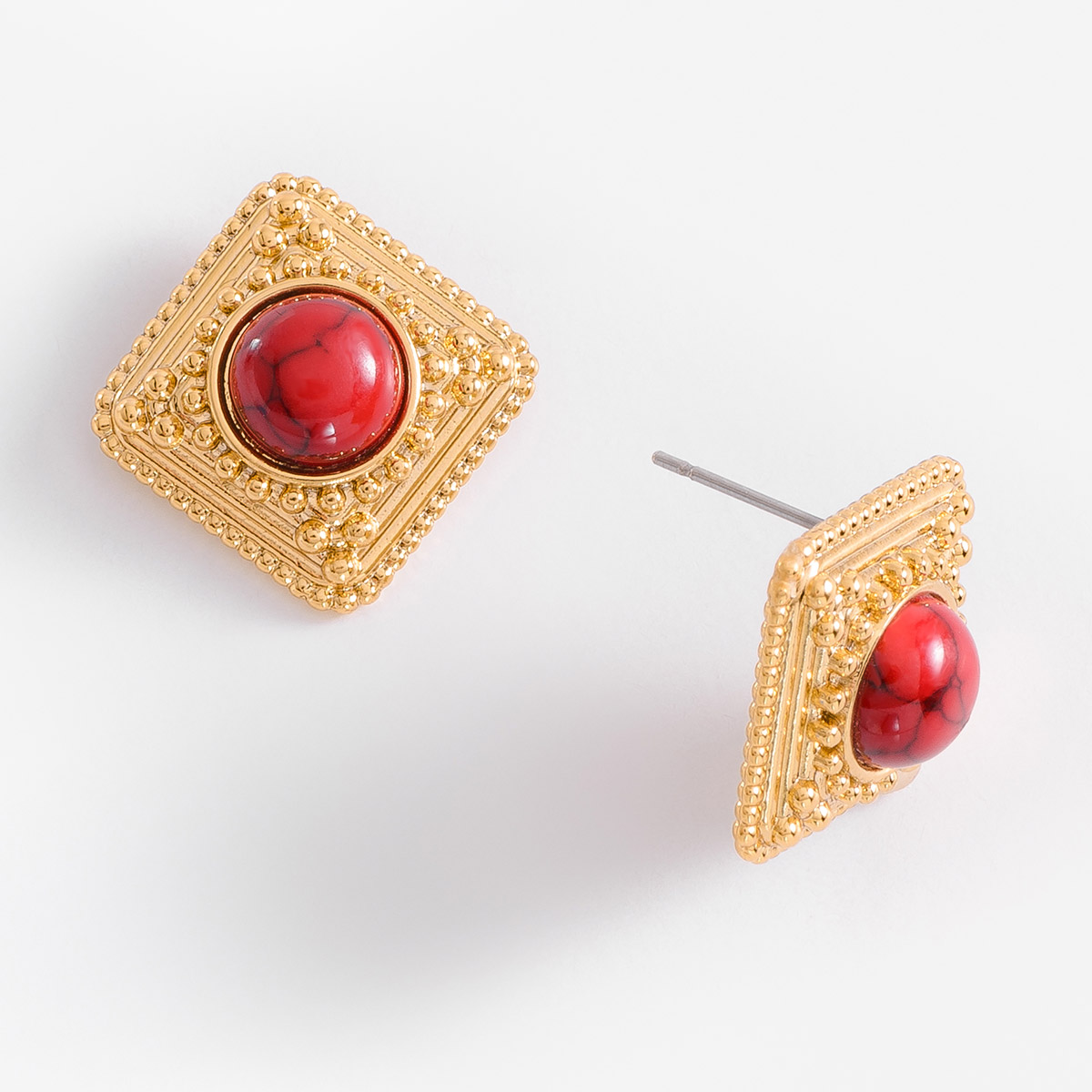 Aretes chicos con poste, en baño de oro, con piedra en tono rojo.