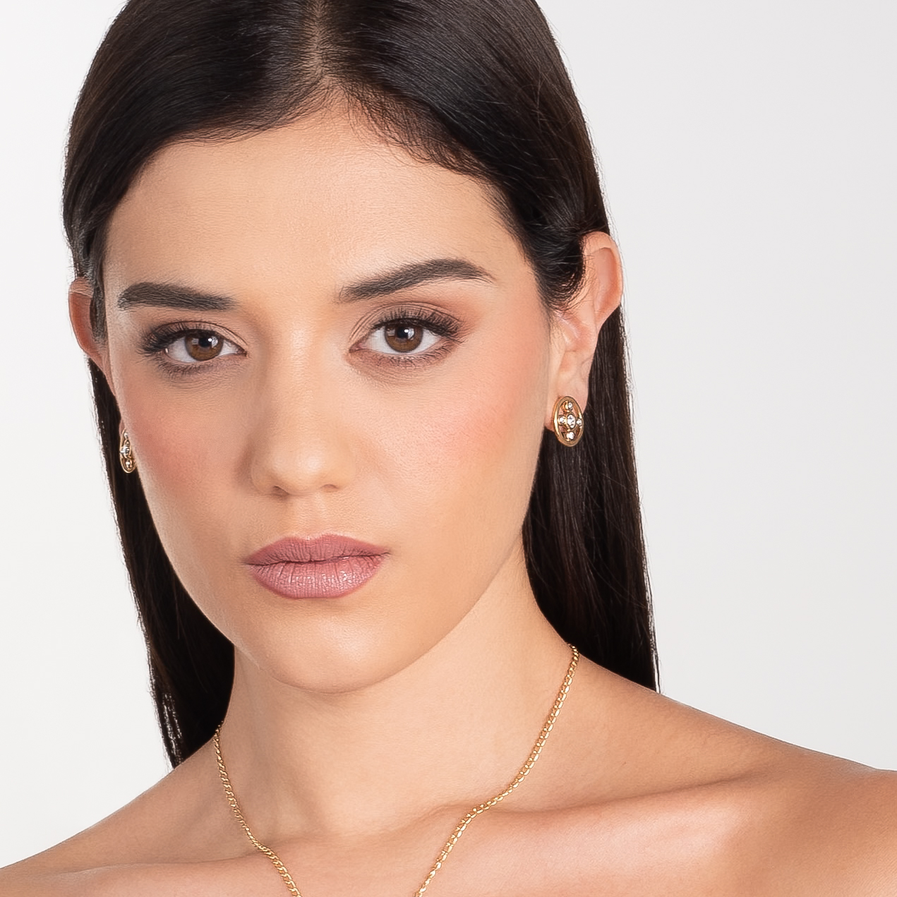 Aretes en baño de oro con piedras en tono cristal diseño circular