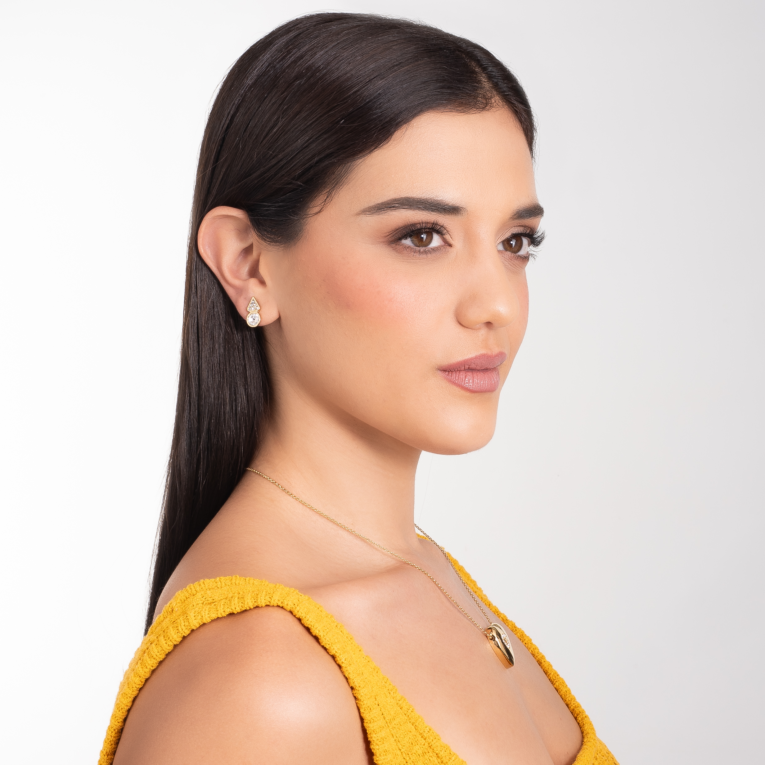 Aretes en baño de oro con piedras en tono cristal diseño geométrico