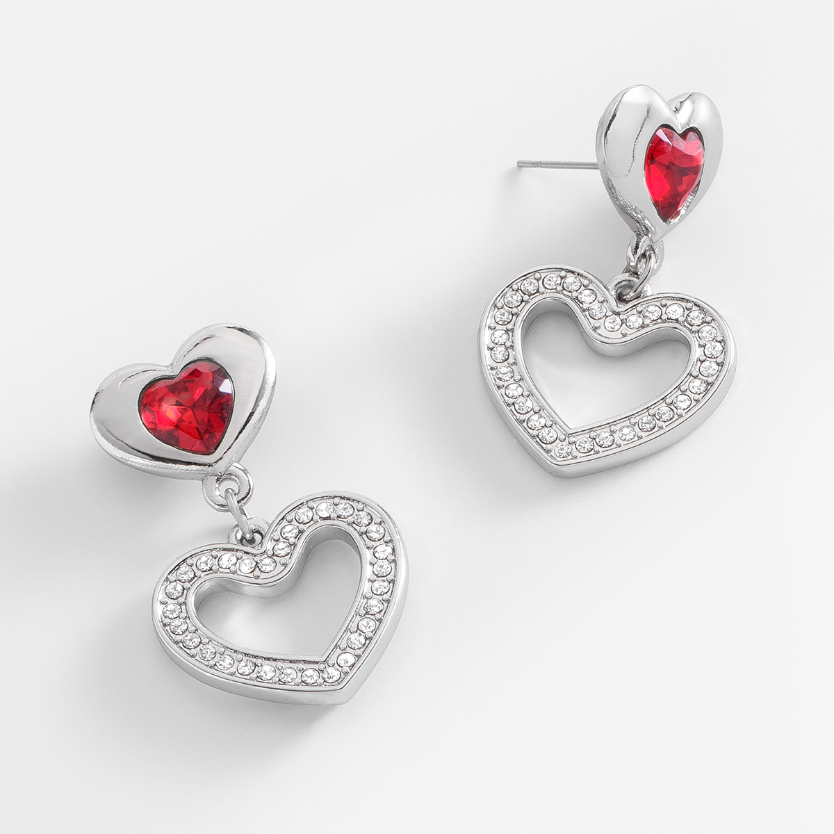 Aretes en forma de corazón, con poste, en baño de platino, con piedras en tono rojo y cristal.