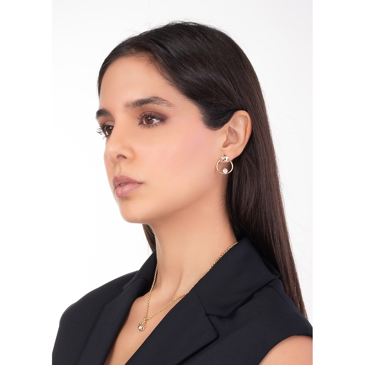 Aretes en baño de oro con forma de aro, decorados con una estrella y piedra en tono cristal.