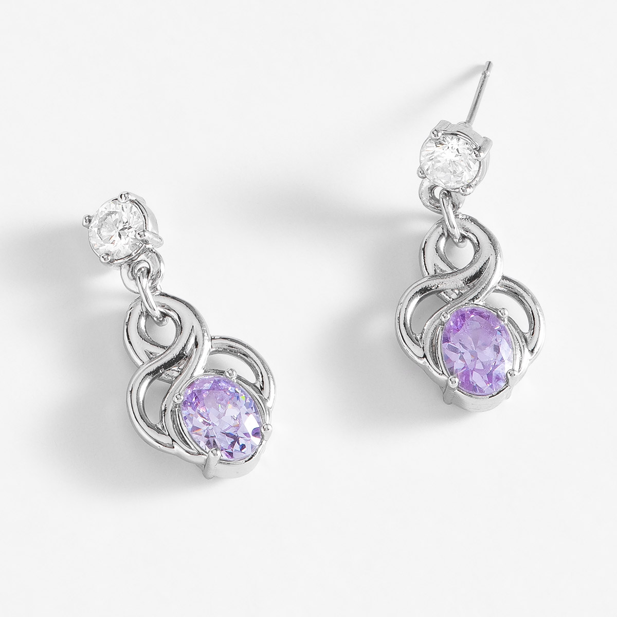 Aretes medianos con poste, en baño de platino, con piedra Diamonice en tono cristal y lila.