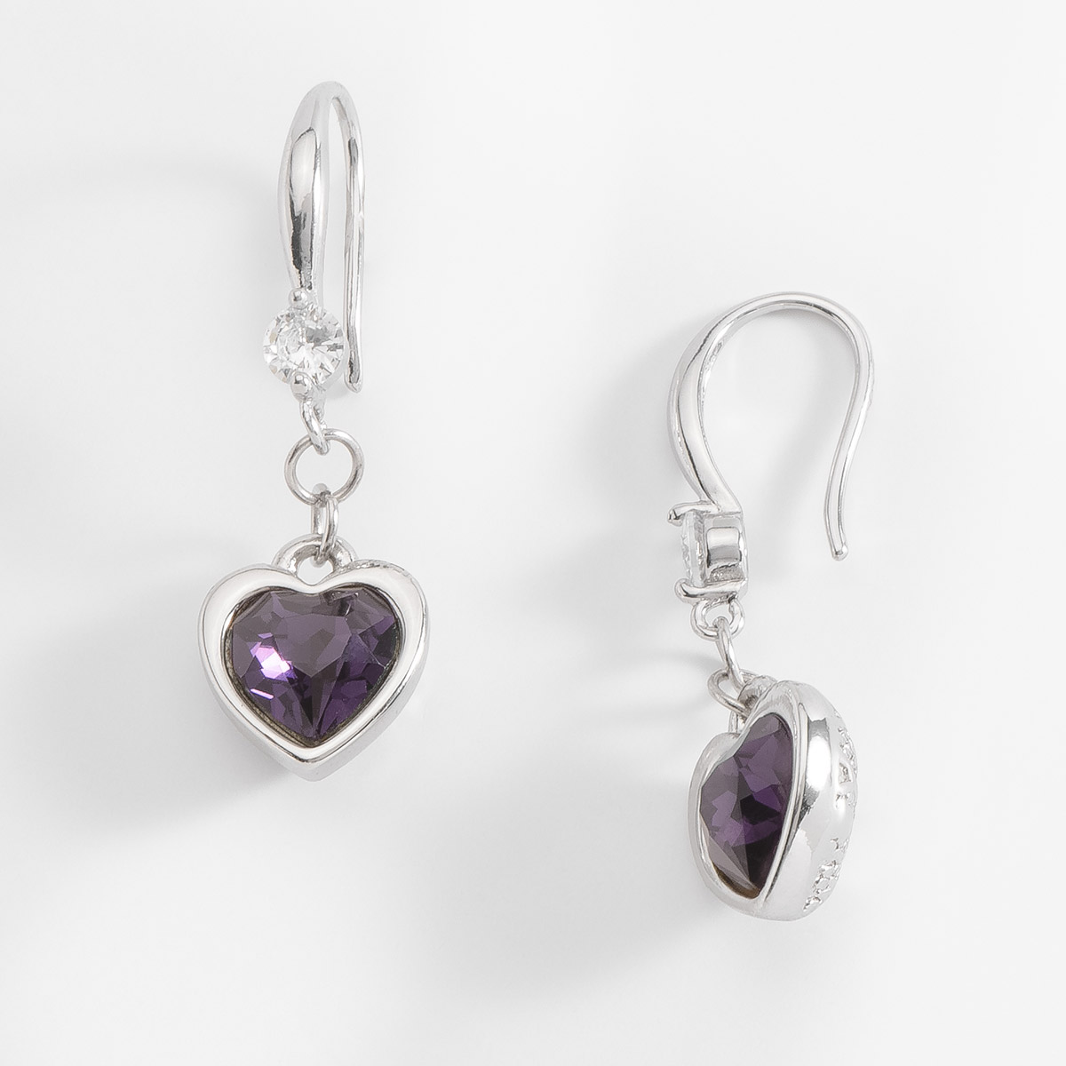 Pendientes con forma de corazón en baño de platino; el corazón cuelga de una piedra Diamonice™ en tono cristal, y al centro destaca una piedra en tono amatista. Combínalos con tu collar.
-        Aretes medianos
-        Garfio
-        Baño de Platino
-        Diamonice™ en tono cristal
-        Piedras en tono amatista
