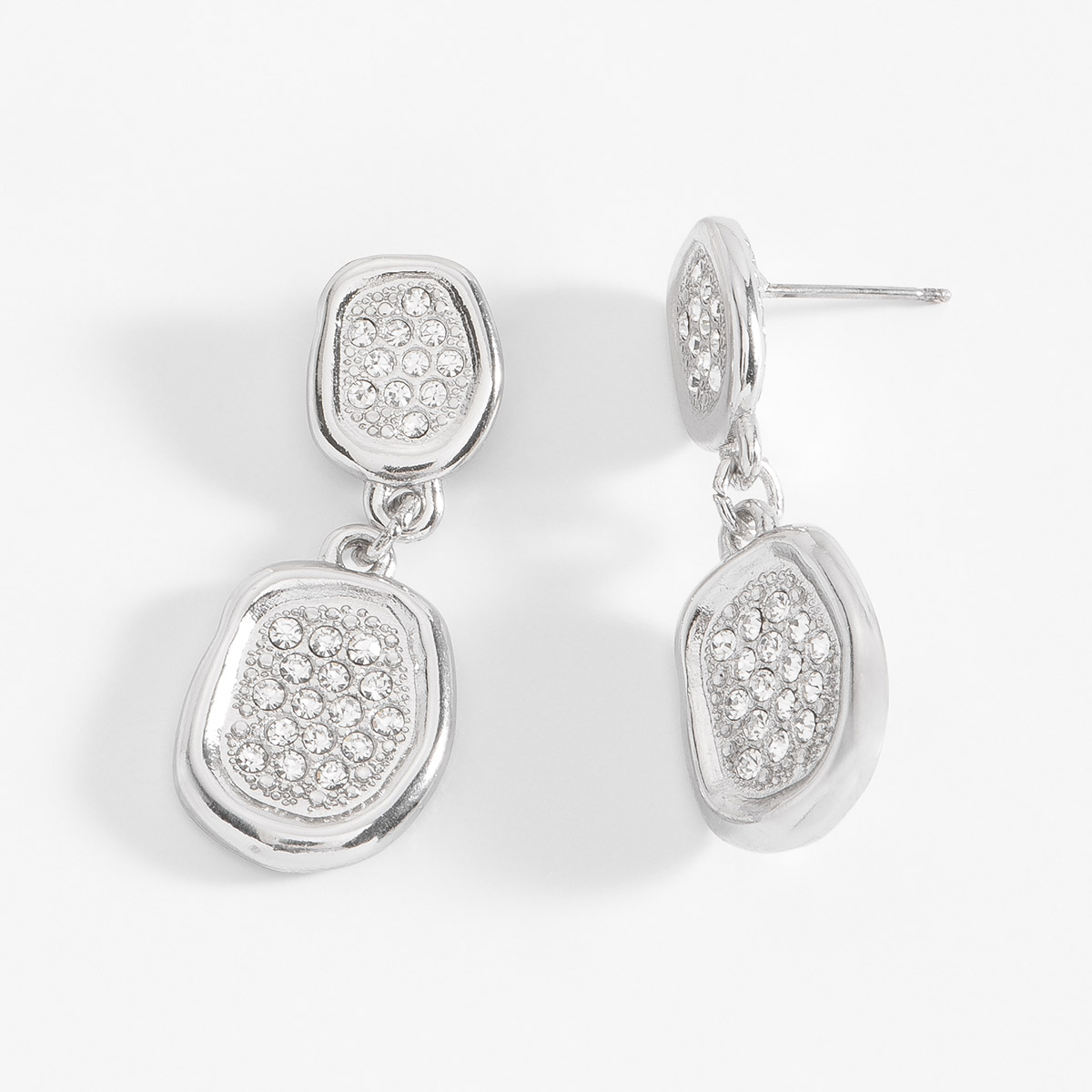 Aretes con forma asimétrica en baño de platino, con piedras en tono cristal al centro. Combínalos con tu collar del mismo juego.
-        Aretes medianos
-        Poste
-        Baño de Platino
-        Piedras en tono cristal
