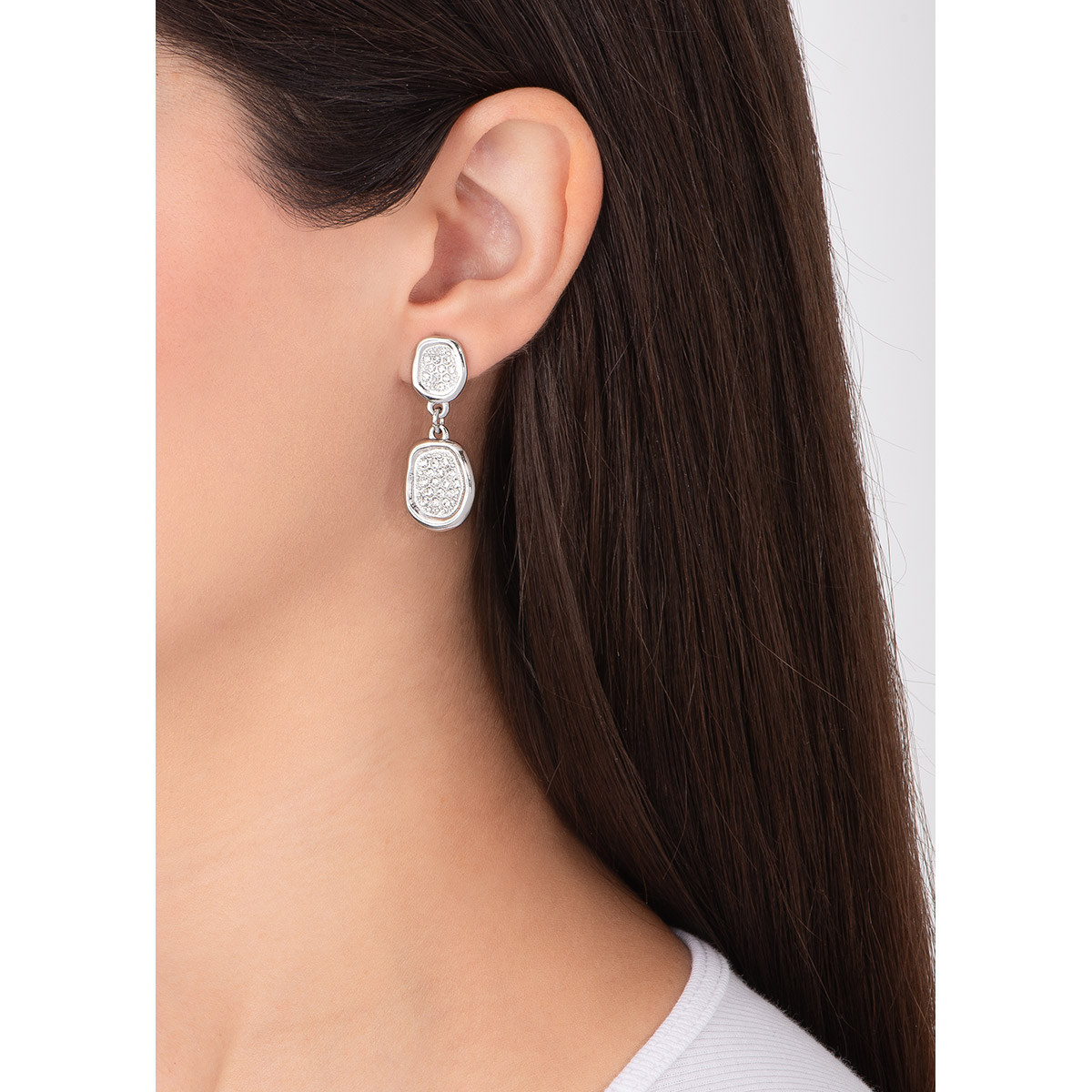 Aretes con forma asimétrica en baño de platino, con piedras en tono cristal al centro. Combínalos con tu collar del mismo juego.
-        Aretes medianos
-        Poste
-        Baño de Platino
-        Piedras en tono cristal
