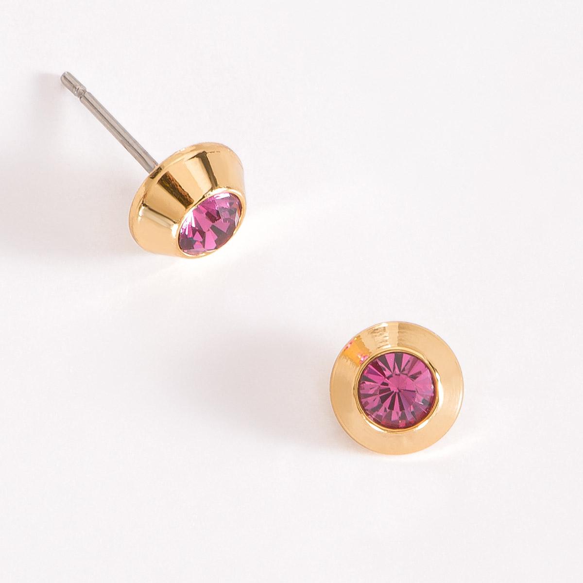 Coquetos aretes en baño de oro, con una piedra incrustada en tono rosa al centro.
-        Aretes chicos
-        Poste
-        Baño de Oro 18k
-        Piedras en tono rosa
