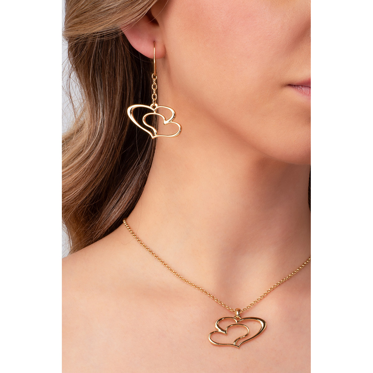 El conjunto perfecto para combinar con tu collar: aretes en baño de oro, con un colgante de líneas que forman el diseño de doble corazón.
-        Aretes largos
-        Garfio
-        Baño de Oro 18k