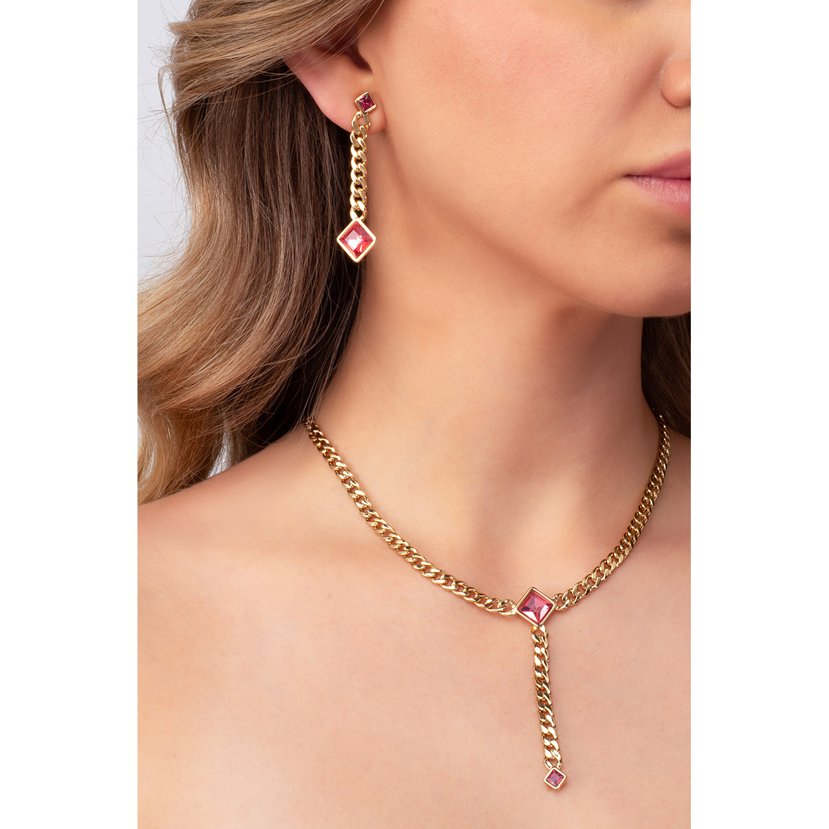 Eslabones planos crean una hilera en baño de oro, de donde destacan dos piedras en tono rosa de diferentes tamaños. Perfectos para complementar con pulsera y collar.
-        Aretes largos
-        Poste
-        Baño de Oro 18k