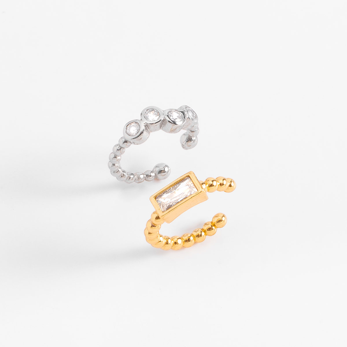 Aretes en baño bitono y diseño moderno, realzados por piedras en tono cristal que añaden un toque brillante y carácter a tu estilo diario.