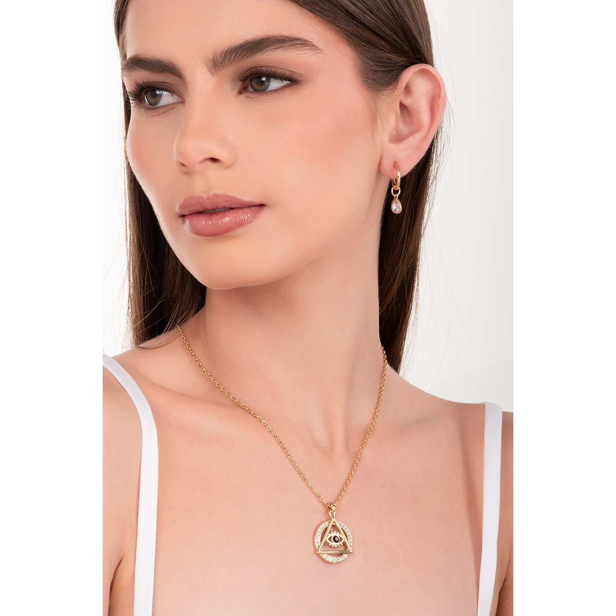 Aretes en baño de oro con dijes en forma de gota y piedras en tono cristal, añadiendo un toque brillante y moderno para realzar cualquier look.