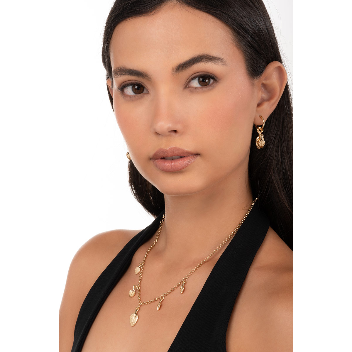 Aretes con charm de hojas y baño de oro que realzan cualquier look con un toque natural y sofisticado.