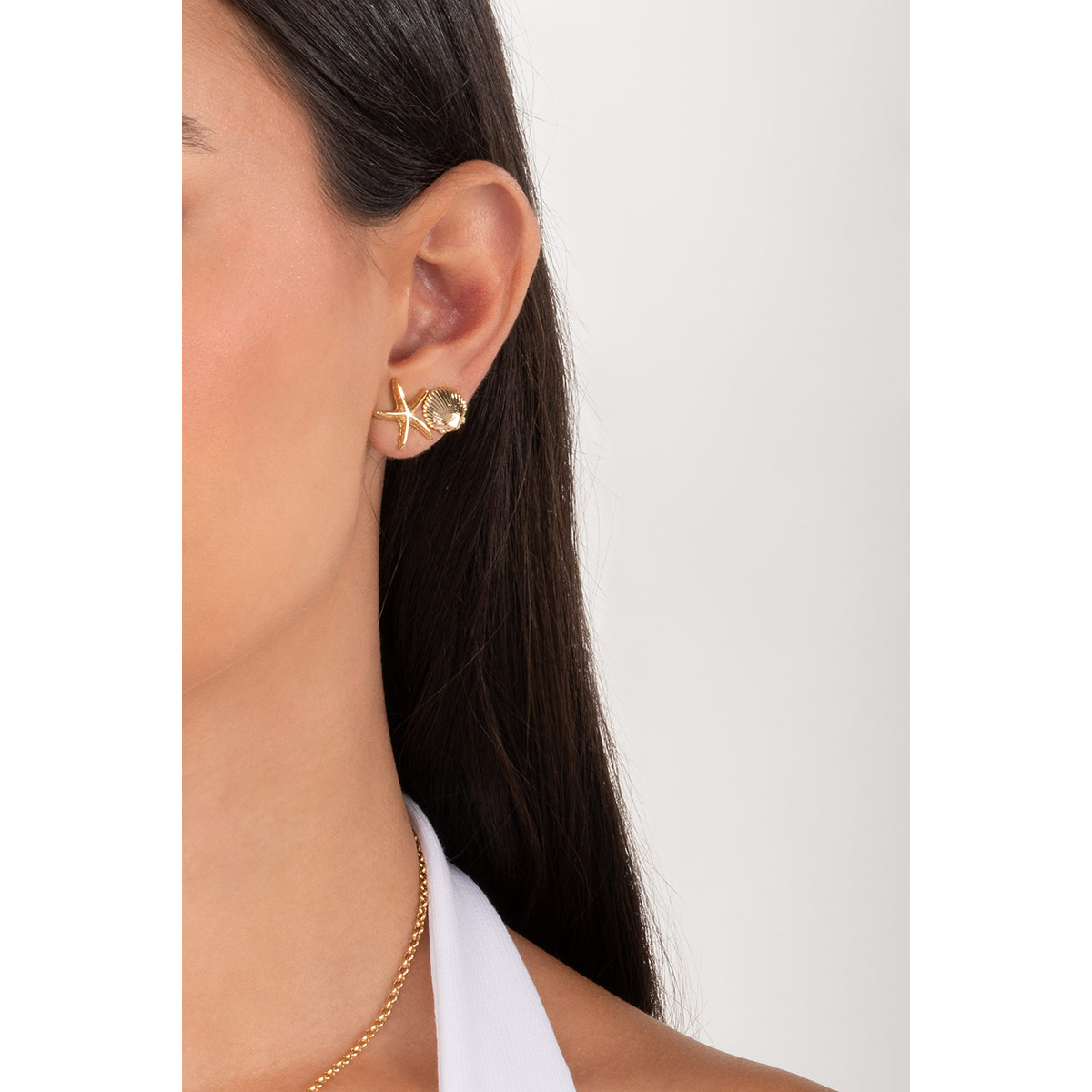 Captura la esencia del océano con estos aretes de broquel. Su delicado diseño de concha, meticulosamente trabajado en baño de oro, es ideal para ti.