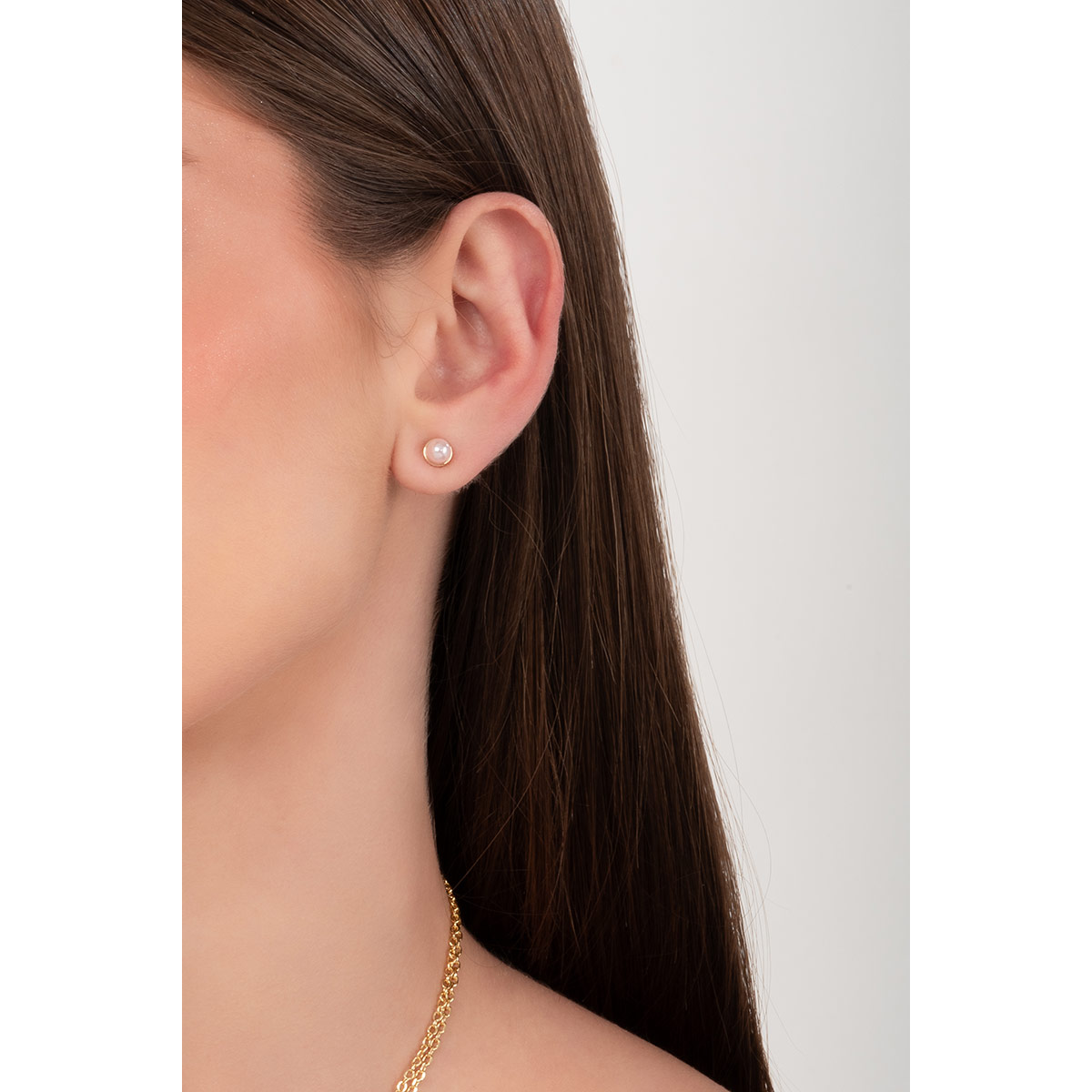 Aretes con baño de oro y perla en tono rosa que aportan un sutil destello a tu look diario realzando cualquier estilo con distinción.
