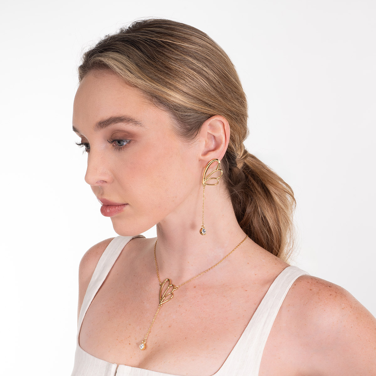 Aretes en baño de oro inspiración pétalos con piedra brillante