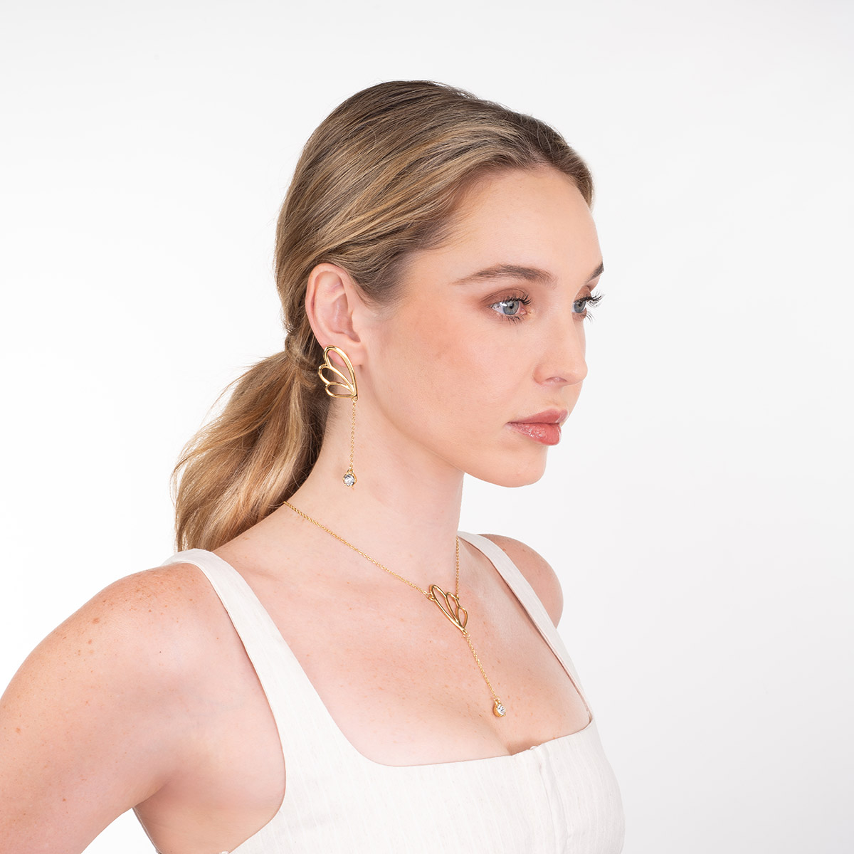 Aretes en baño de oro inspiración pétalos con piedra brillante