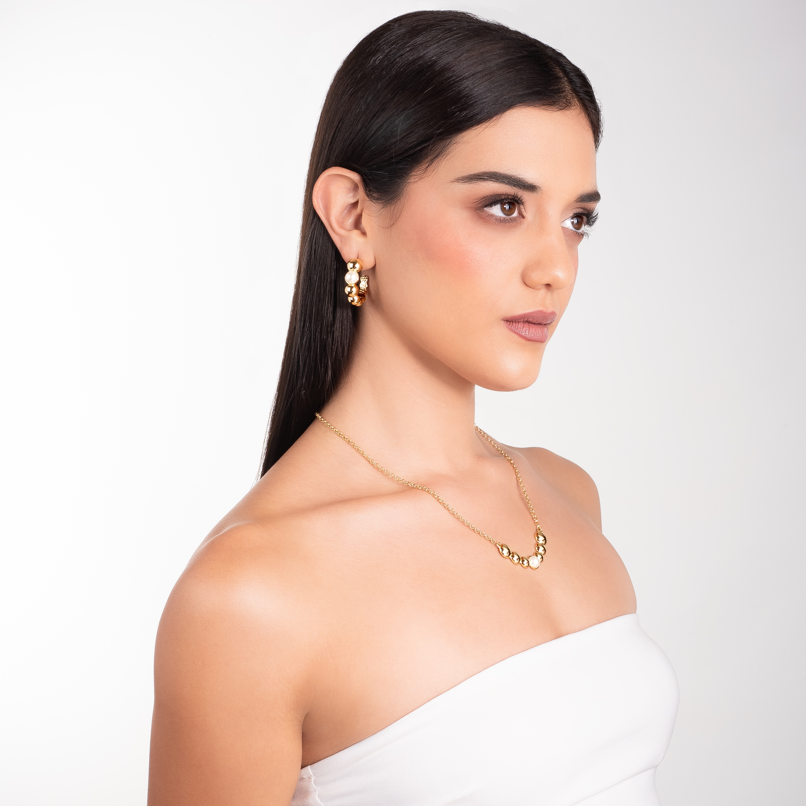 Aretes en baño de oro con esferas pulidas y perla en tono crema