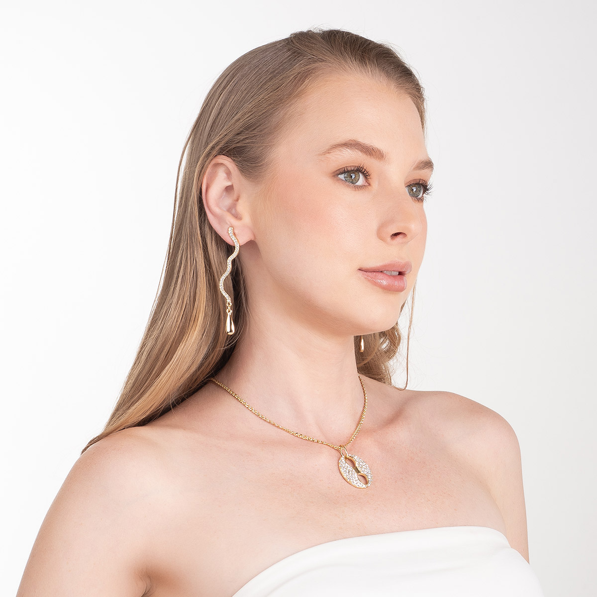 Aretes en baño de oro forma ondulada y piedras brillante