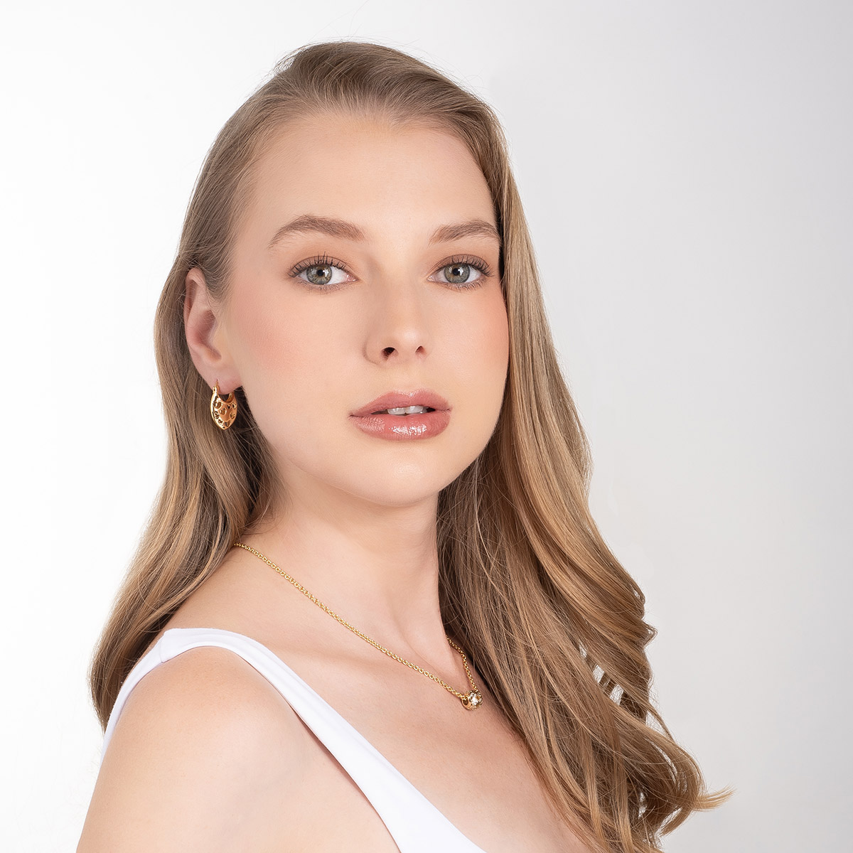 Aretes en baño de oro gota calada con motivos de corazones