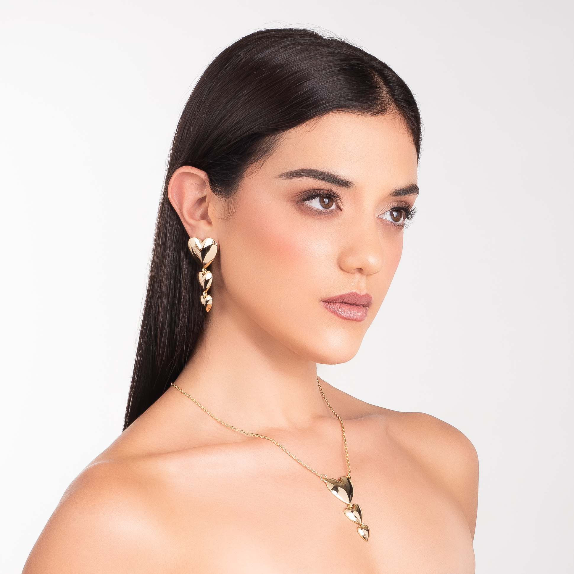 Aretes en baño de oro con tres corazones colgantes y acabado pulido