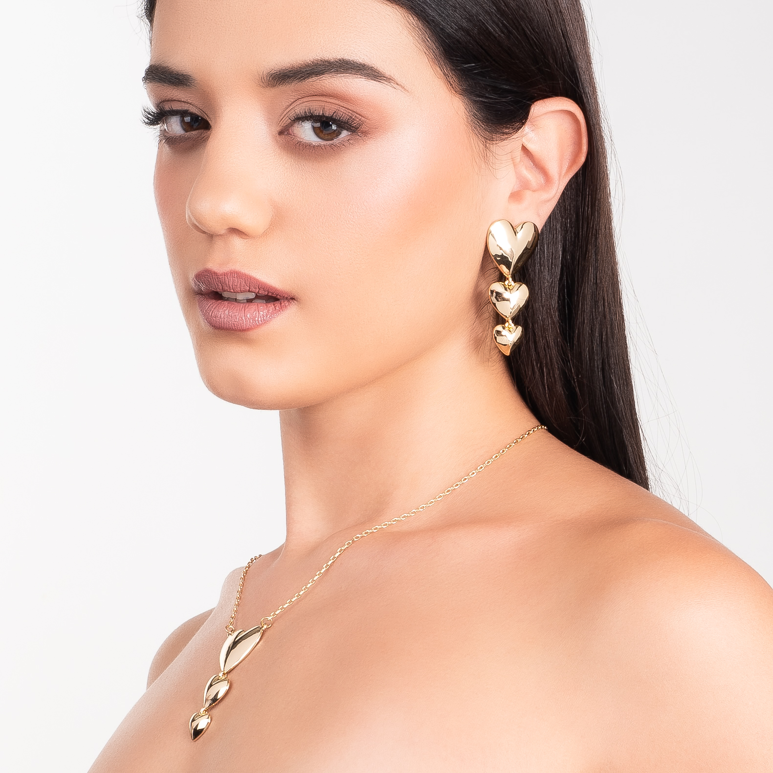 Aretes en baño de oro con tres corazones colgantes y acabado pulido