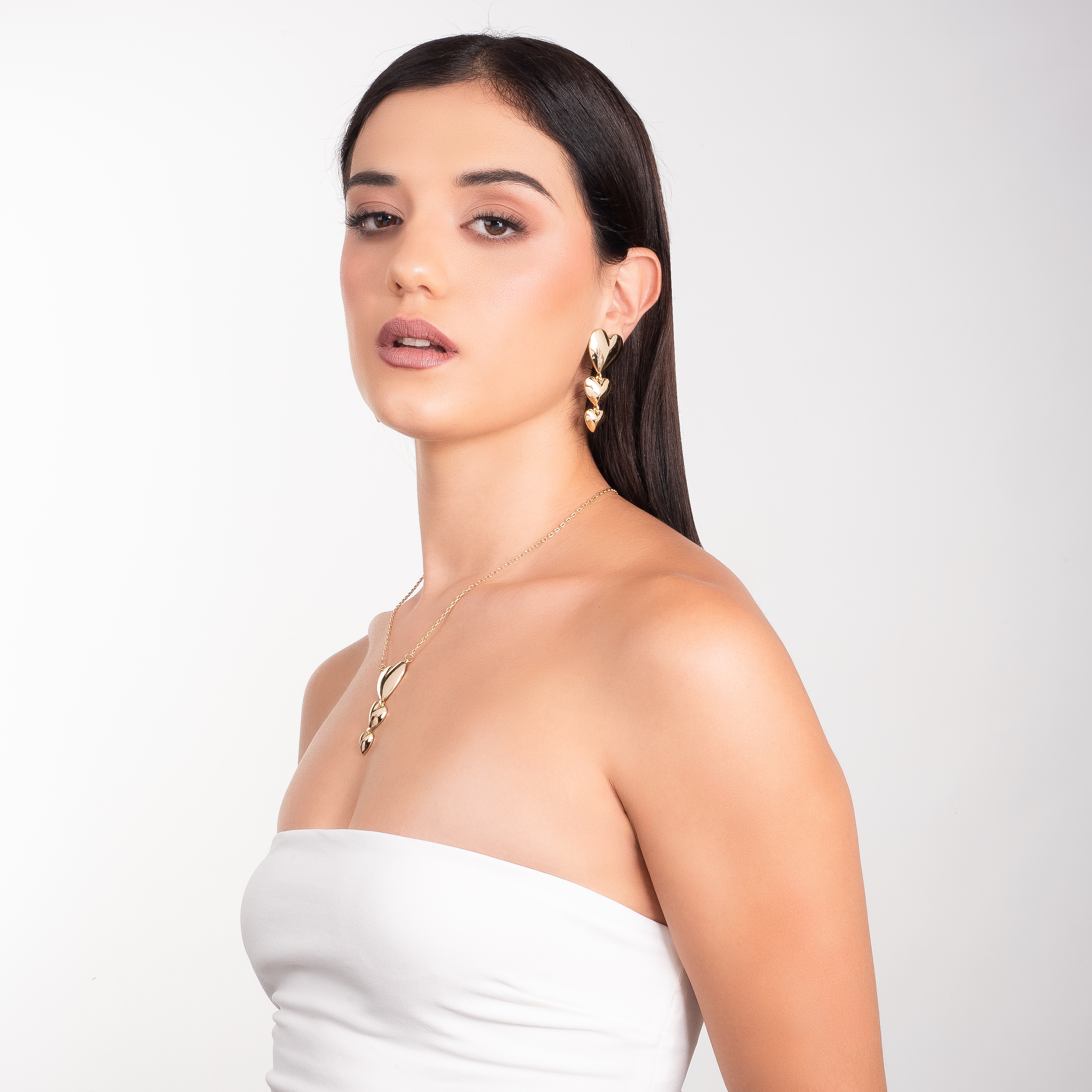 Aretes en baño de oro con tres corazones colgantes y acabado pulido