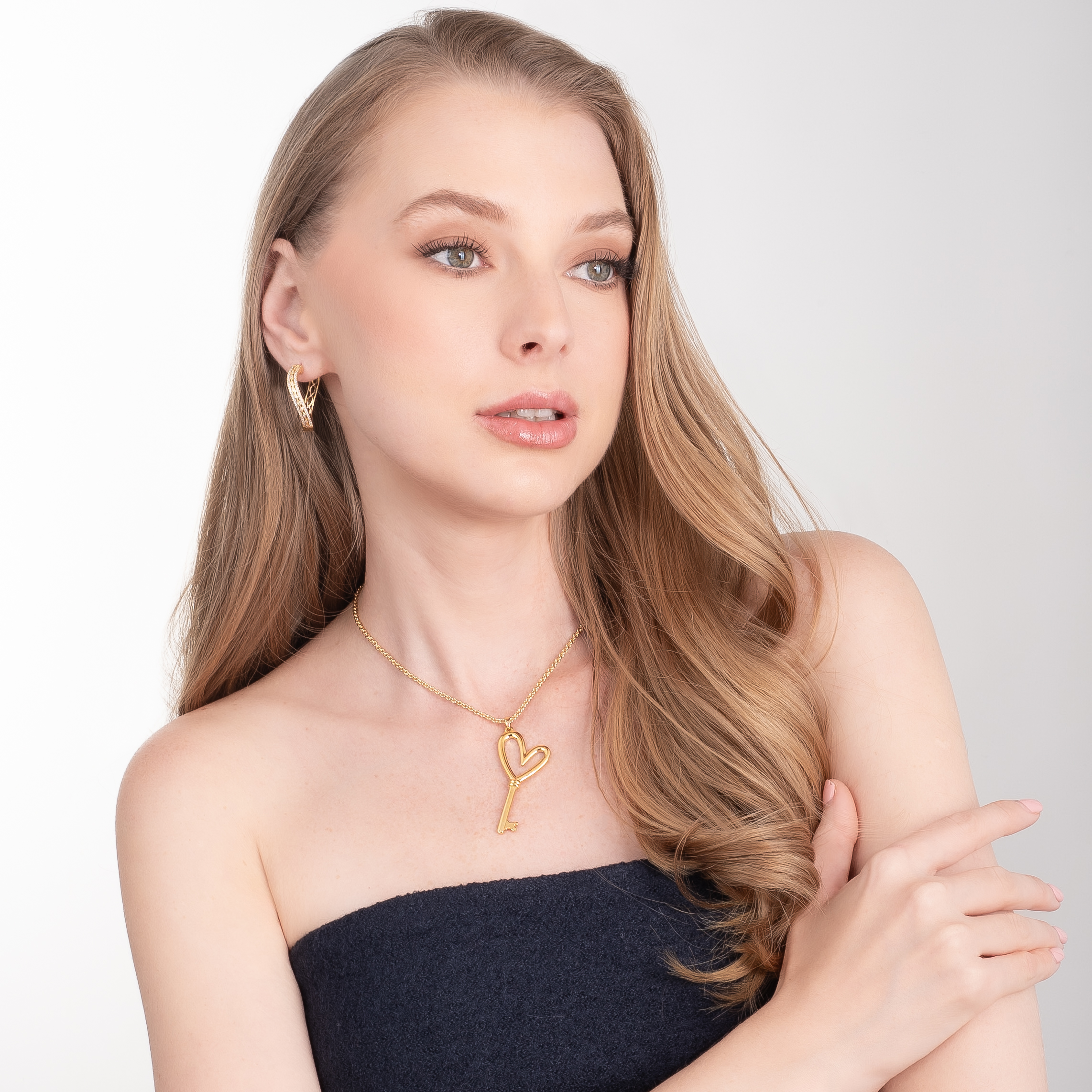 Aretes en baño de oro con piedras en tono cristal diseño cruzado