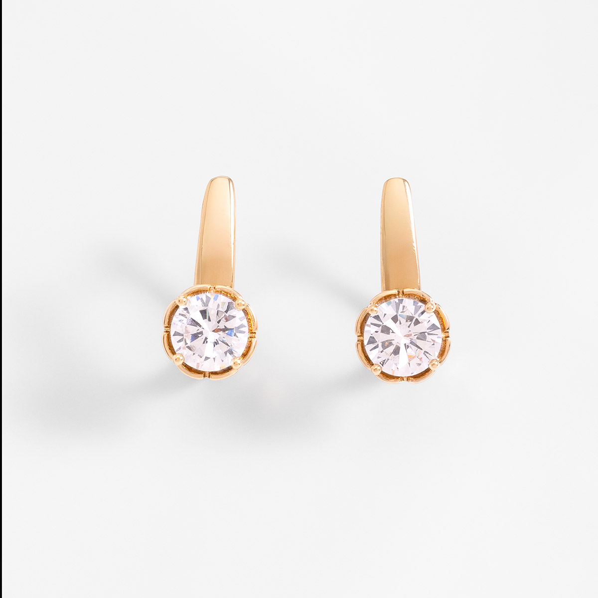 Aretes en baño de oro con piedra en tono cristal diseño poste