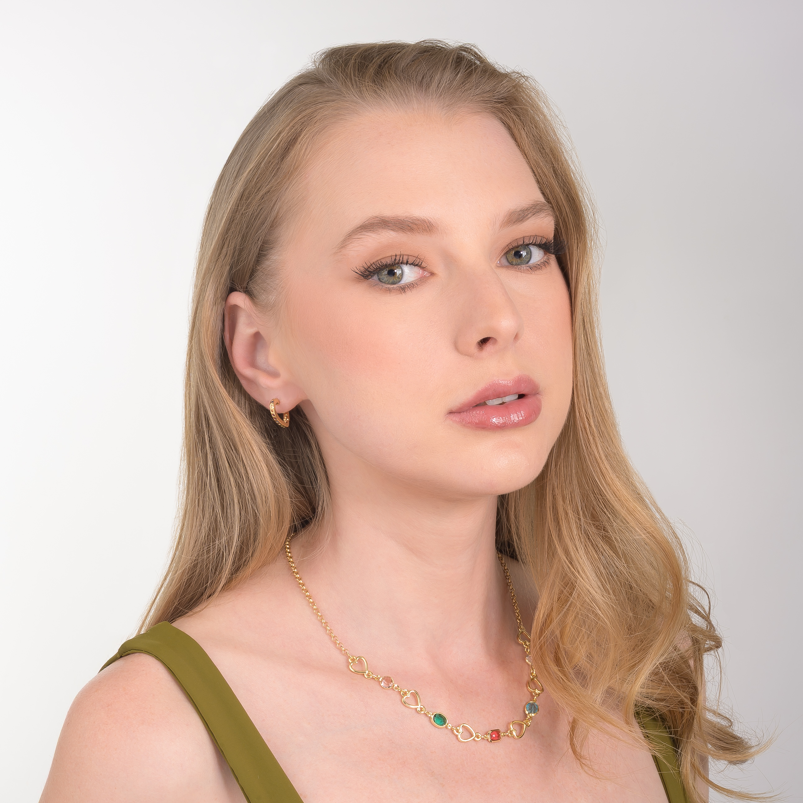 Aretes en baño de oro con diseño de corazón y aplicaciones de piedras multicolor