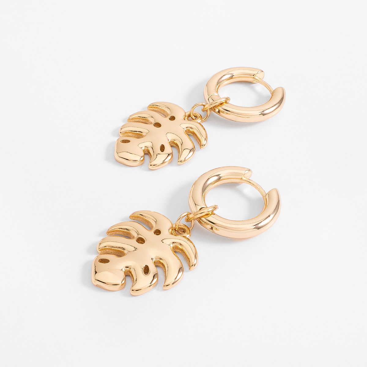 Aretes aro en baño de oro con dije hoja tropical pulida