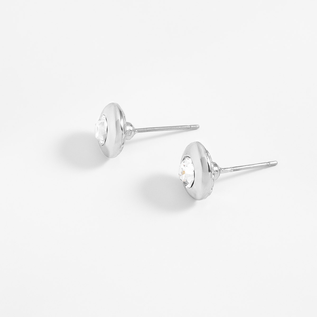 Aretes en baño de rodio con piedra en tono cristal diámetro 1 cm
