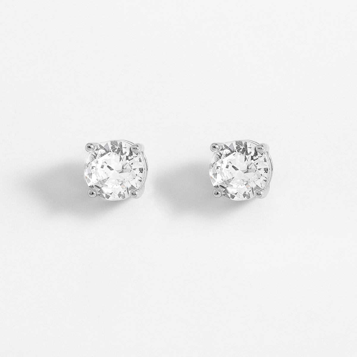 Aretes en baño de rodio piedra en tono cristal diámetro 0.4 cm