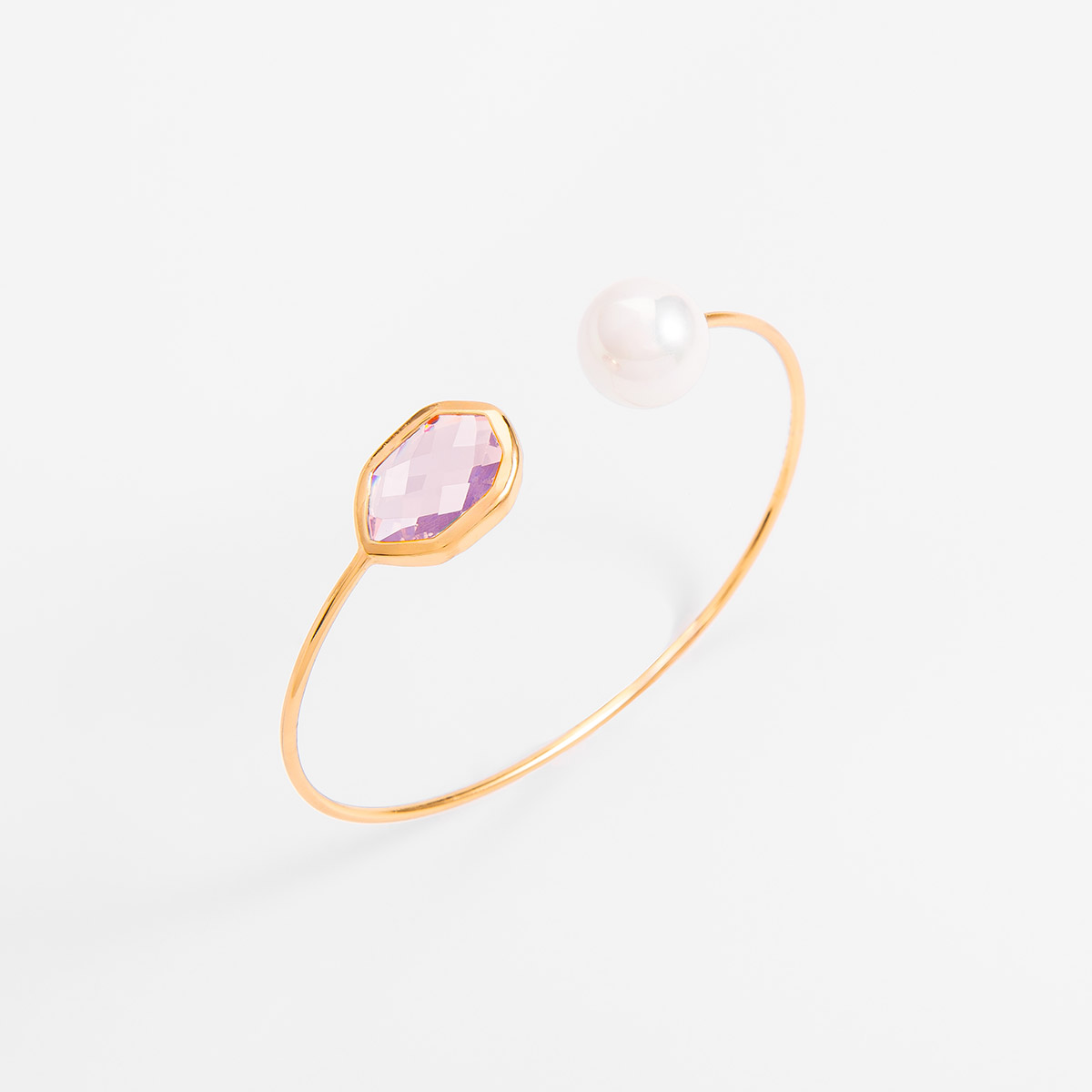 Pulsera rígida en baño de oro, con dos incrustaciones en ambos lados: una perla en tono cream y una piedra geométrica en tono rosa. Combínala con tu collar y aretes.
-        Pulsera 
-        Medida Ajustable
-        Baño de Oro 18k
-        Perla en tono cream
-        Piedra en tono rosa