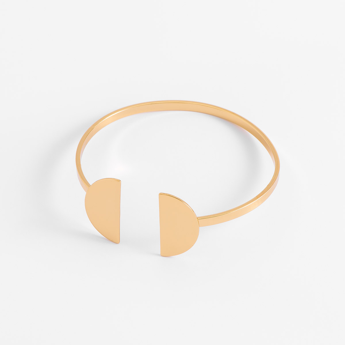 Brazalete ajustable con diseño innovador, con dos semicírculos en baño de oro, que añaden un estilo contemporáneo.
-        Pulsera
-        Medida ajustable
-        Baño de Oro 18k
