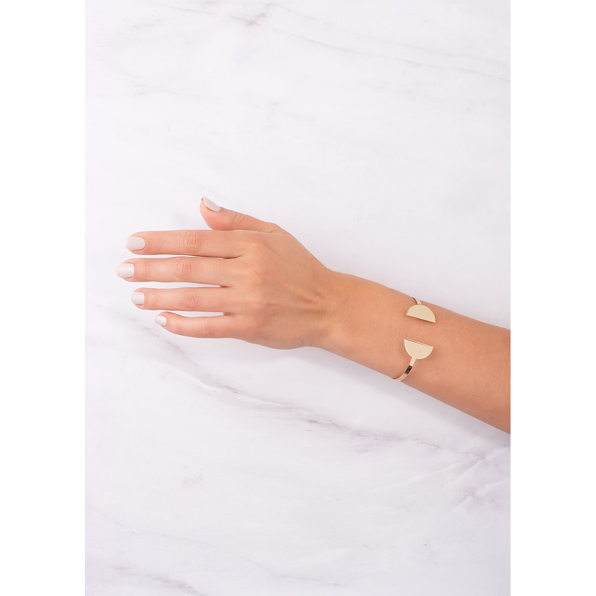 Brazalete ajustable con diseño innovador, con dos semicírculos en baño de oro, que añaden un estilo contemporáneo.
-        Pulsera
-        Medida ajustable
-        Baño de Oro 18k
